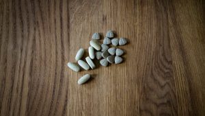 From above of set of different assorted medical pills arranged on lumber surface