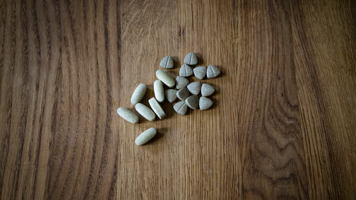 From above of set of different assorted medical pills arranged on lumber surface